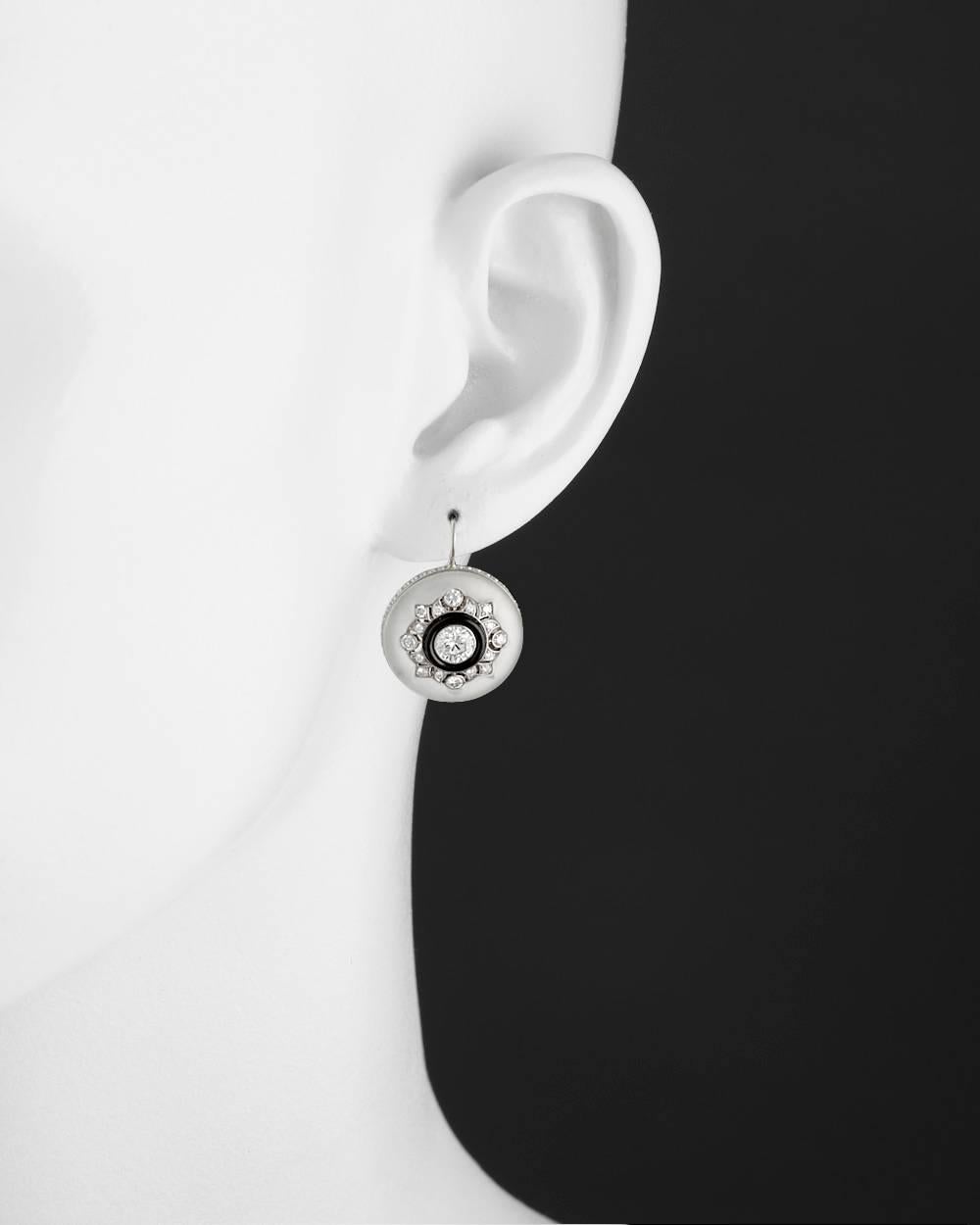Drop earrings, showcasing a circular-shaped polished rock crystal centering an inset larger round-cut diamond within a carved black onyx frame and openwork round-cut diamond-set lattice, the earrings mounted in 18k white gold with a round-cut