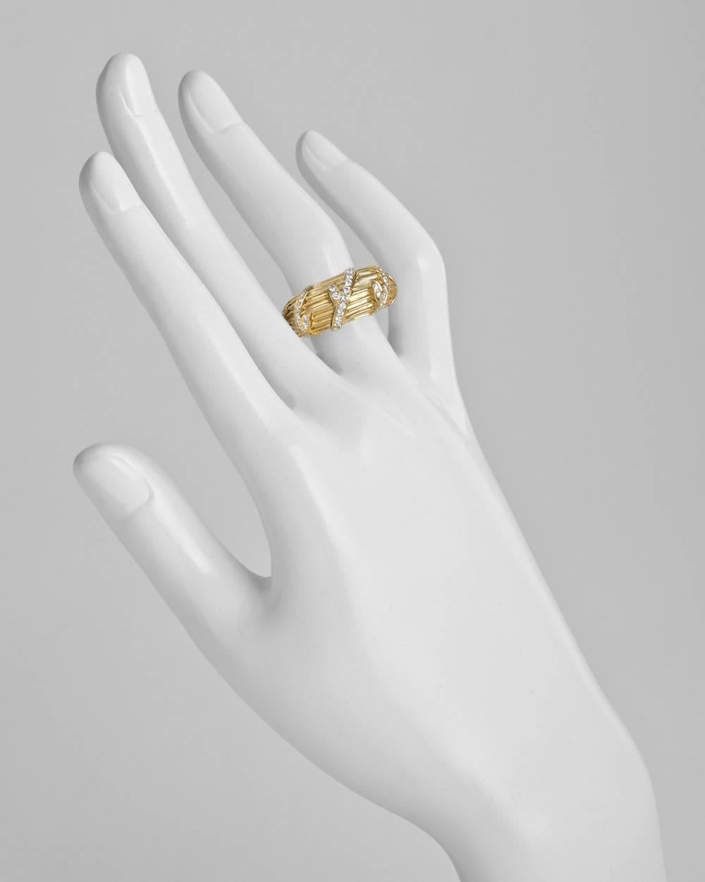 Band ring, accented by a five section diamond-set vine motif to the front, in 18k yellow gold, numbered 005447 and signed Cartier, stamped 1994. 12.3mm band width. Size 4.5 (European - size 48). This ring cannot be re-sized.
