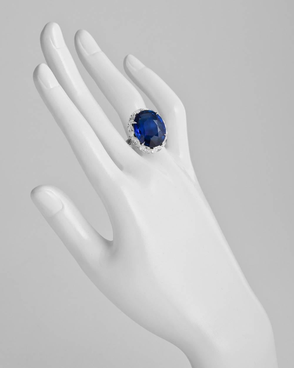 Ceylon sapphire ring, showcasing a natural no-heat oval-shaped sapphire weighing 22.22 carats, framed by ten colorless oval-shaped diamonds weighing approximately 4.10 total carats (F-color, VVS-VS clarity), in platinum. Accompanied by the AGL