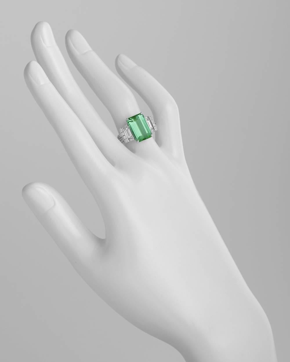 Mint tourmaline and diamond ring, centering an emerald-cut mint tourmaline weighing 6.12 carats, accented by two trapeze-cut diamonds weighing 0.68 carats, four half bullet-shaped diamonds weighing 0.37 total carats, eight square-cut diamonds