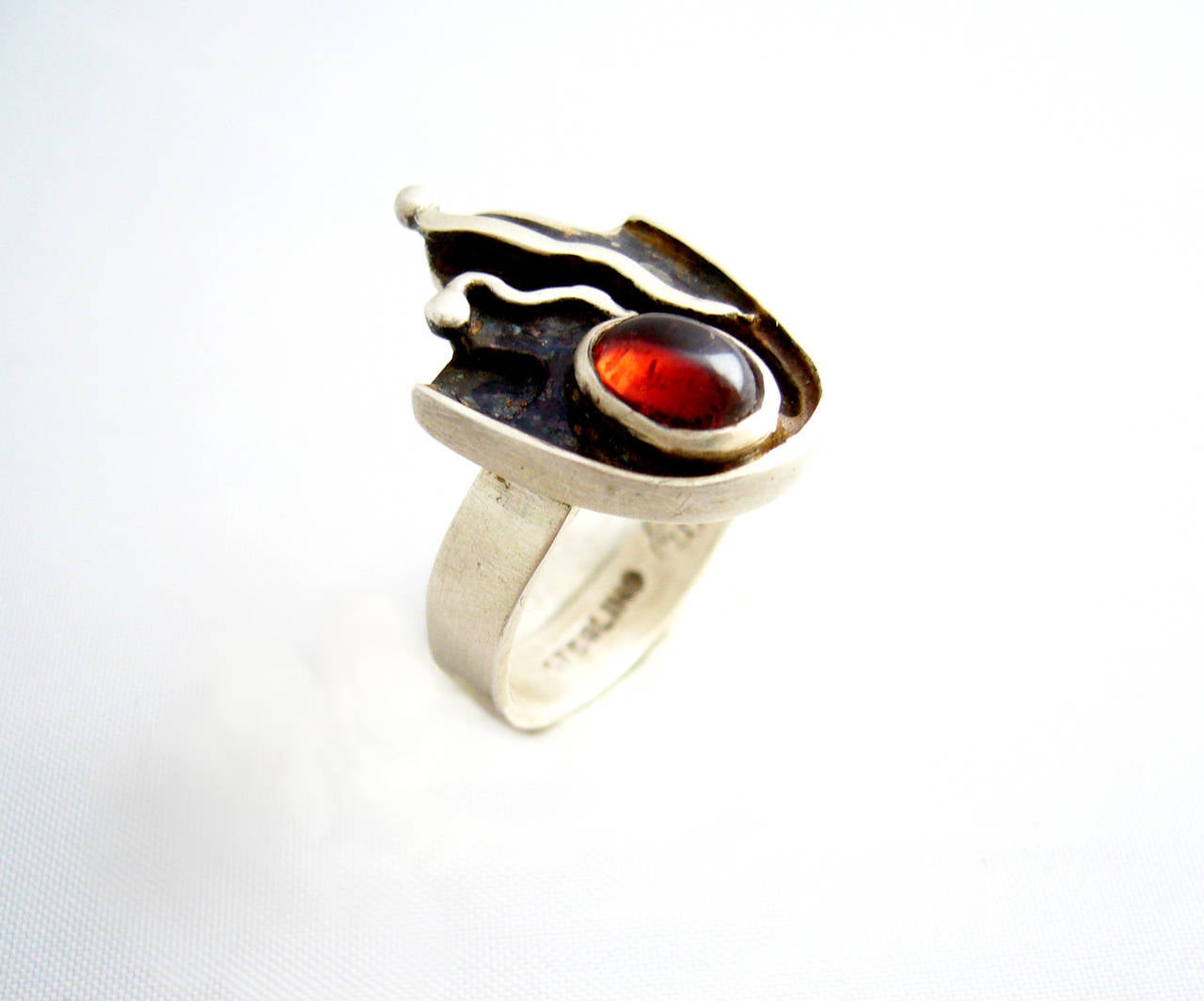 A rare, sterling silver and garnet cabochon ring created by Sam Kramer of New York, circa 1950.  Ring is a finger size 7.  Signed Sterling along with the Kramer hallmark of a mushroom.  In very good vintage condition. 

Kramer's studio was located