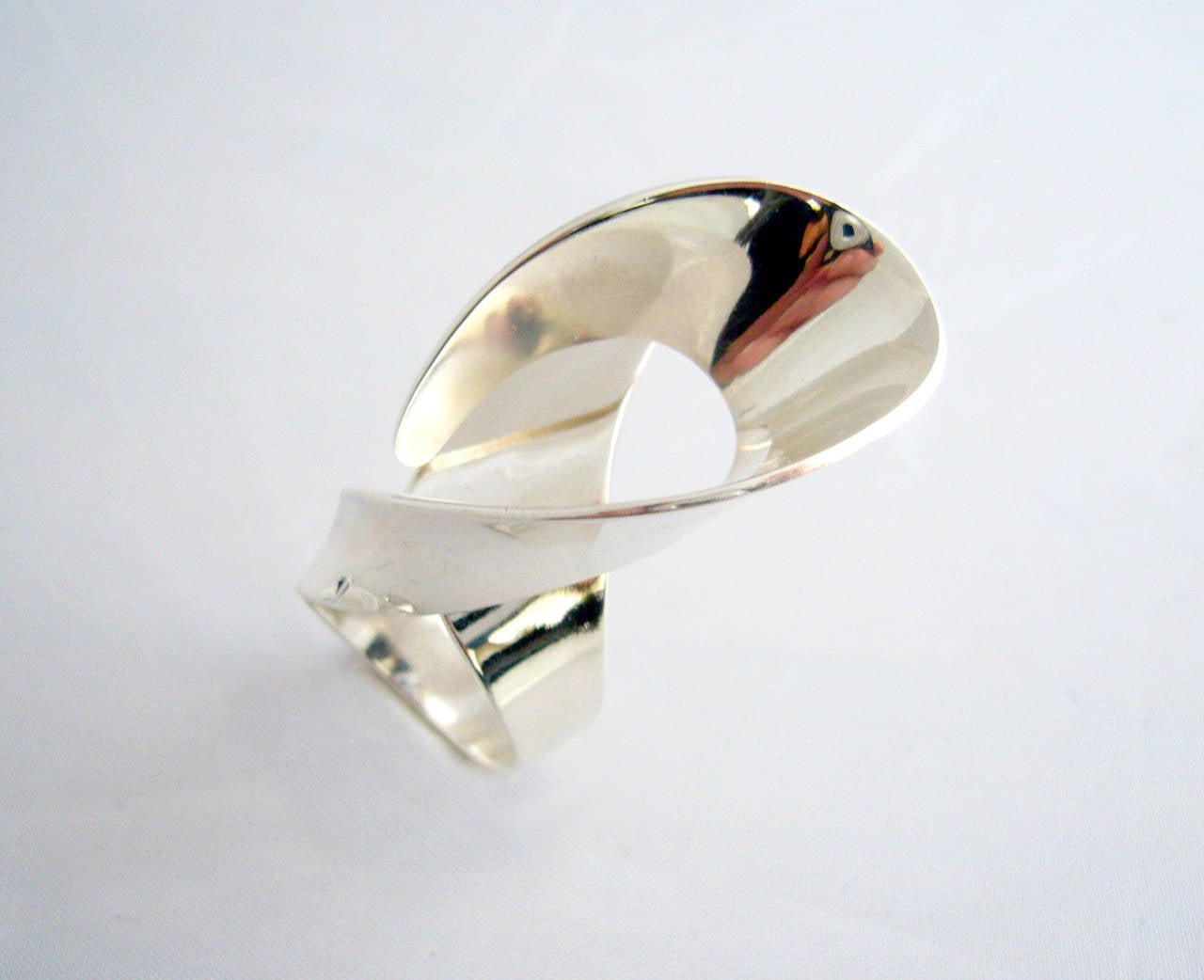Paula Haivaoja for Kaunis Koru sterling silver ring, circa 1972.  Ring is comprised of one piece of looping sterling silver that makes up the design along with the shank and has great presence when worn.  Currently a finger size 8 and does have some
