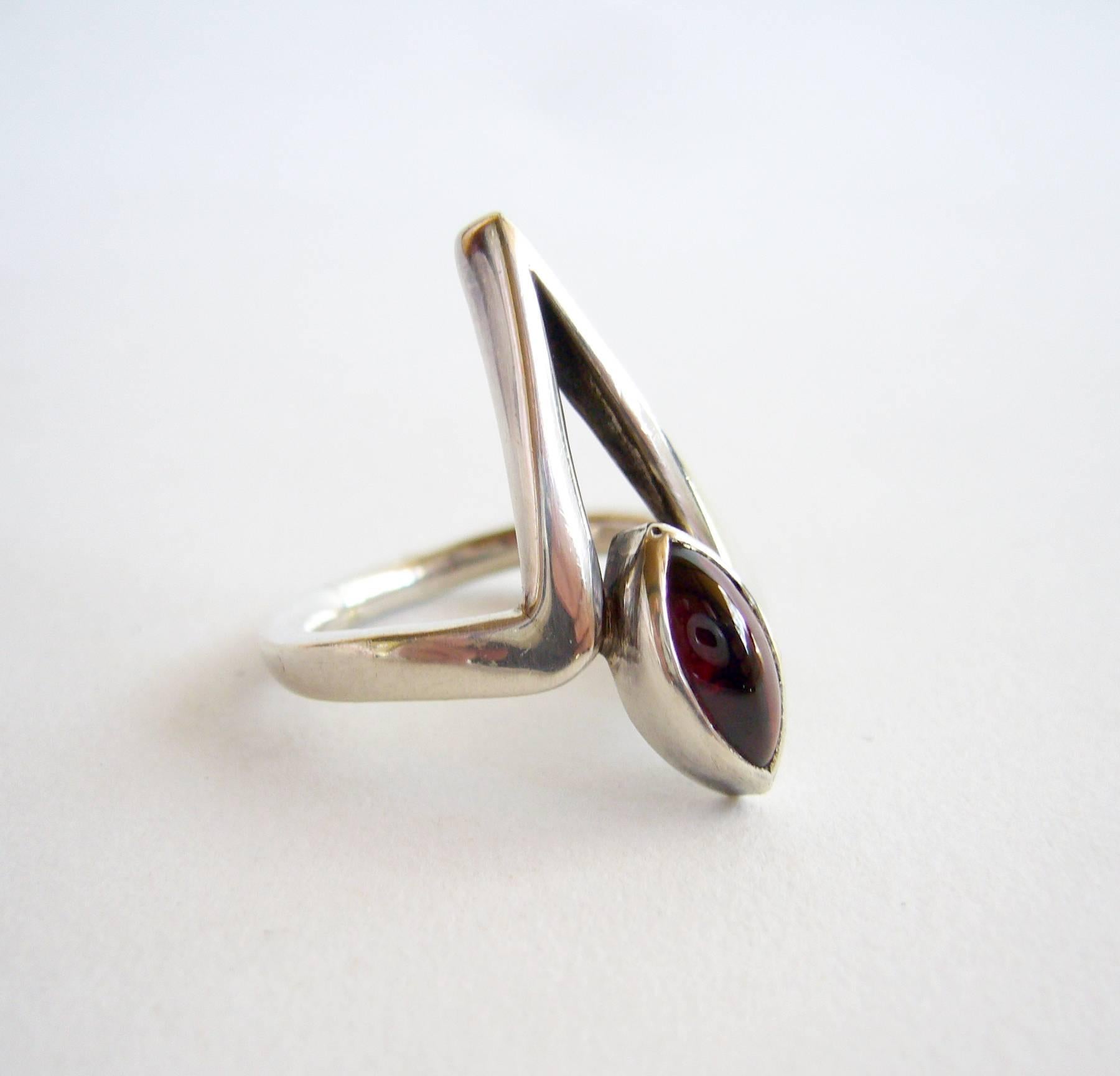 Sterling silver and garnet ring created by American modernist jeweler, Jack Nutting of San Francisco.  Ring is a finger size 6.5, length of the face measures 3/4