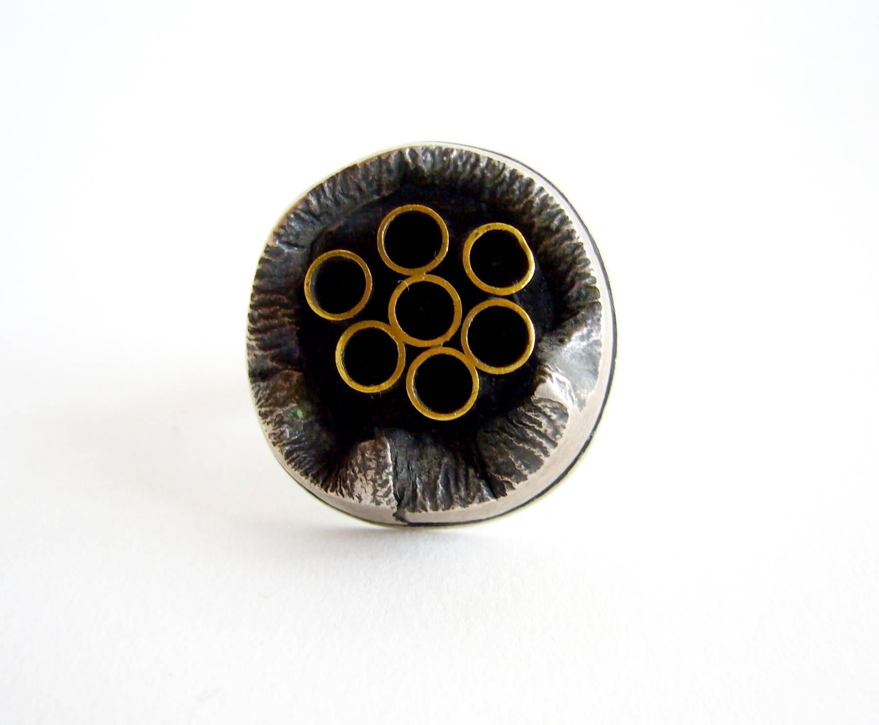 Sterling silver crater-like ring with brass tubes created by silversmith James Parker of San Diego, California.  Parker was an early member of the Allied Craftsmen of San Diego which started in the 1940's.  His jewelry was featured in the show 