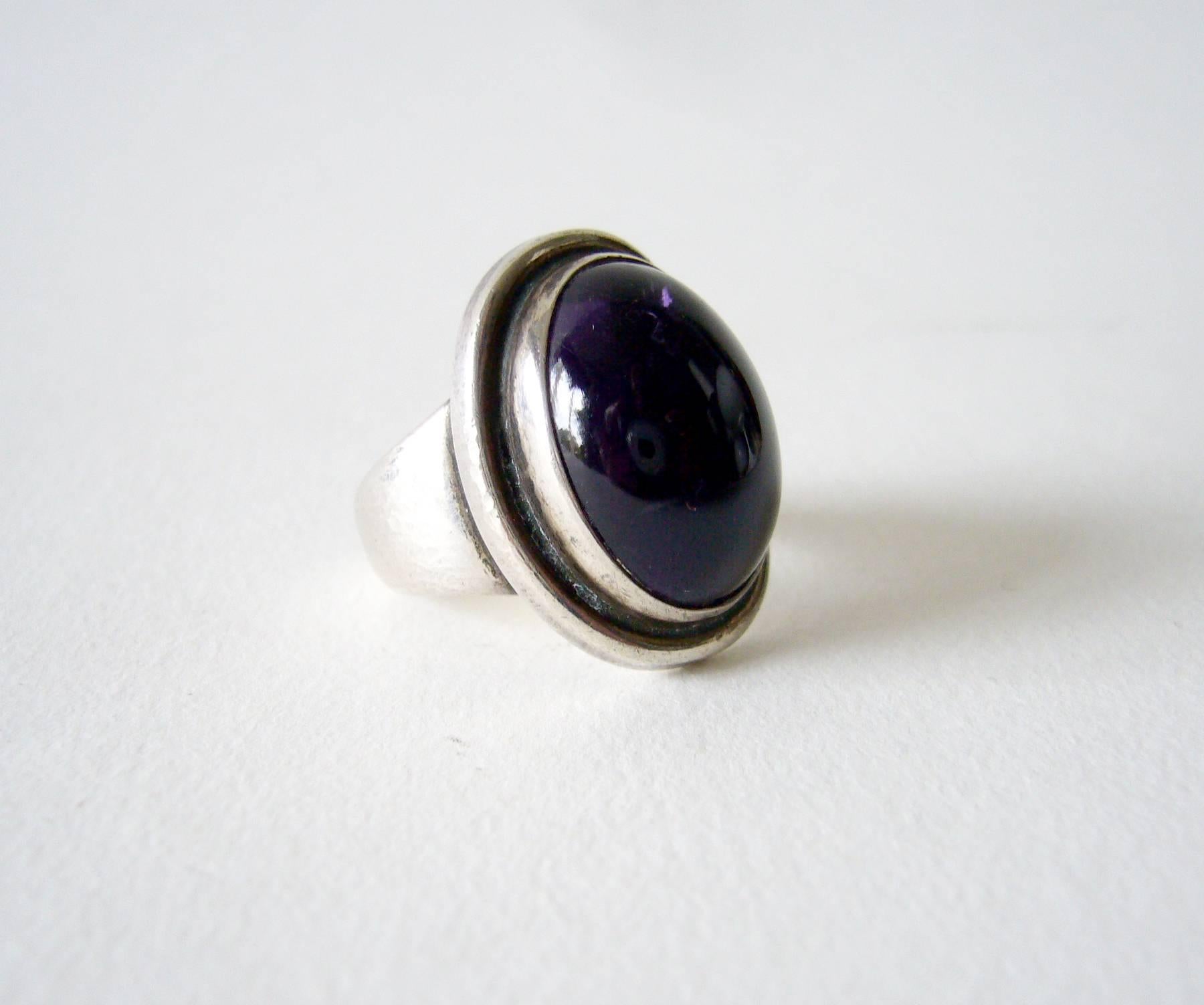 Hammered finish amethyst and sterling silver 48A ring designed by Harald Nielsen for Georg Jensen.  Ring is a finger size 4.5 -4.75 and is signed Georg Jensen, 46A, Denmark.  In very good vintage condition.