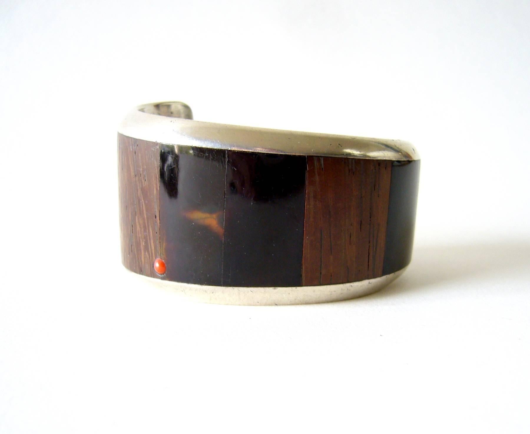 1960's Native American sterling silver cuff bracelet with wood, shell inlay and coral cab accent.  Bracelet has the influence of Hopi jeweler, Charles Loloma. It has an inner circumference measurement of 5.25