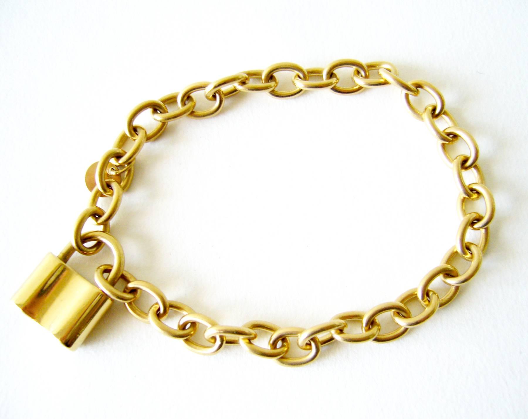 Padlock charm bracelet in 18k gold by Tiffany & Co.  Bracelet measures 7 7/8" long and features an operable padlock that opens and closes.  Signed 750, T & CO., 1837.  30.7 grams.  In very good condition.  
