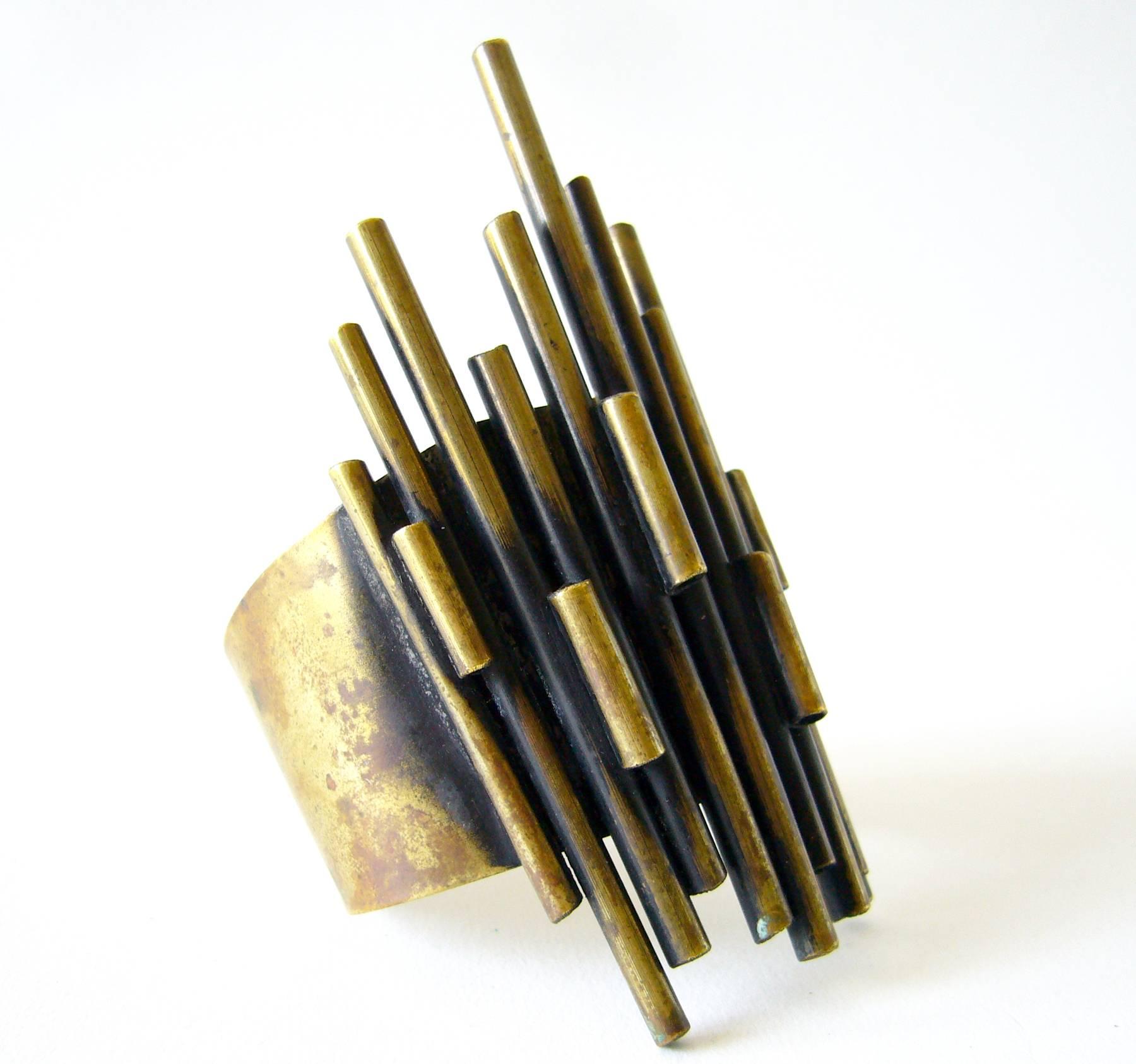 Wide cuff bracelet made of layered bronze tubes, created by Industria Argentina. The face measures 4.25