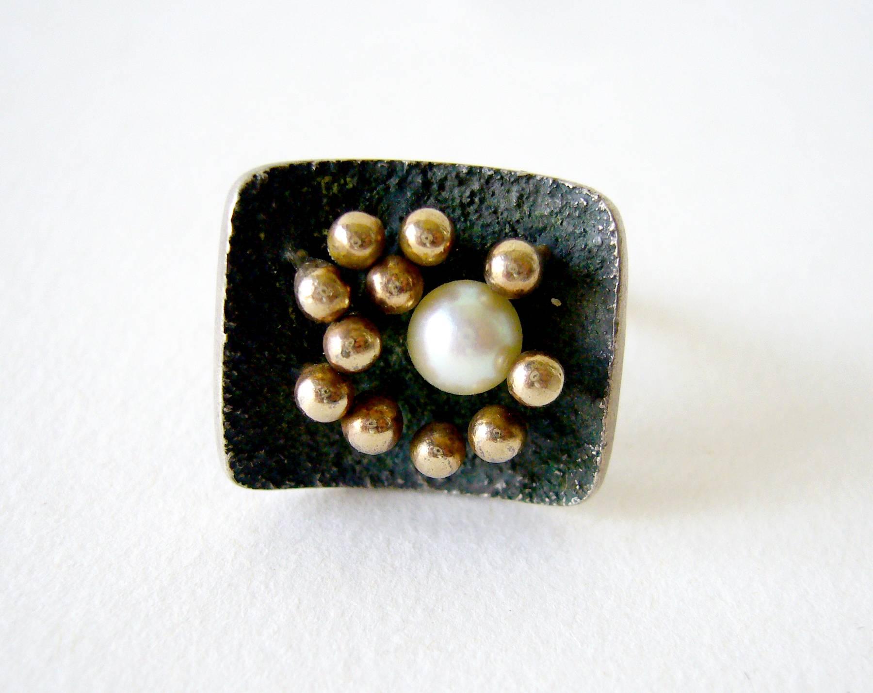 Sterling silver ring with 14k gold spores surrounding a freshwater pearl mounted on an oxidized, textured face created by Jay Tuttle of San Jose, California.  Ring is a finger size 6 and is signed Tuttle, Sterling.  An unconventional alternative to