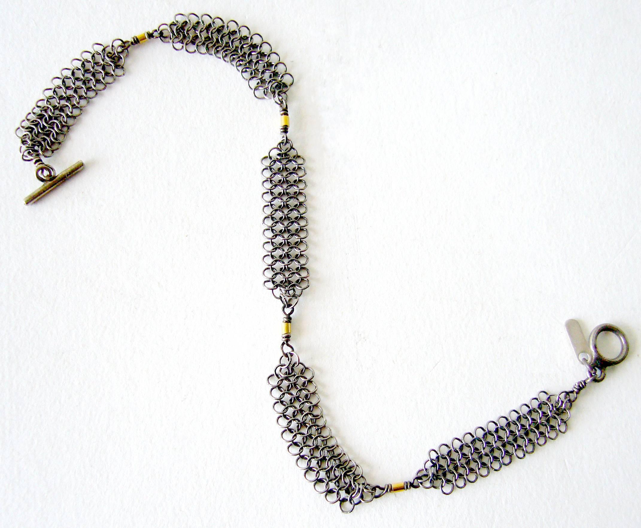 Sterling silver chain maille with 14k gold accent beads created by Allison Stern of San Francisco, California.  Bracelet measures 8" in length by .25" wide.  Signed on a sterling tag A. Stern.  In excellent vintage condition.  