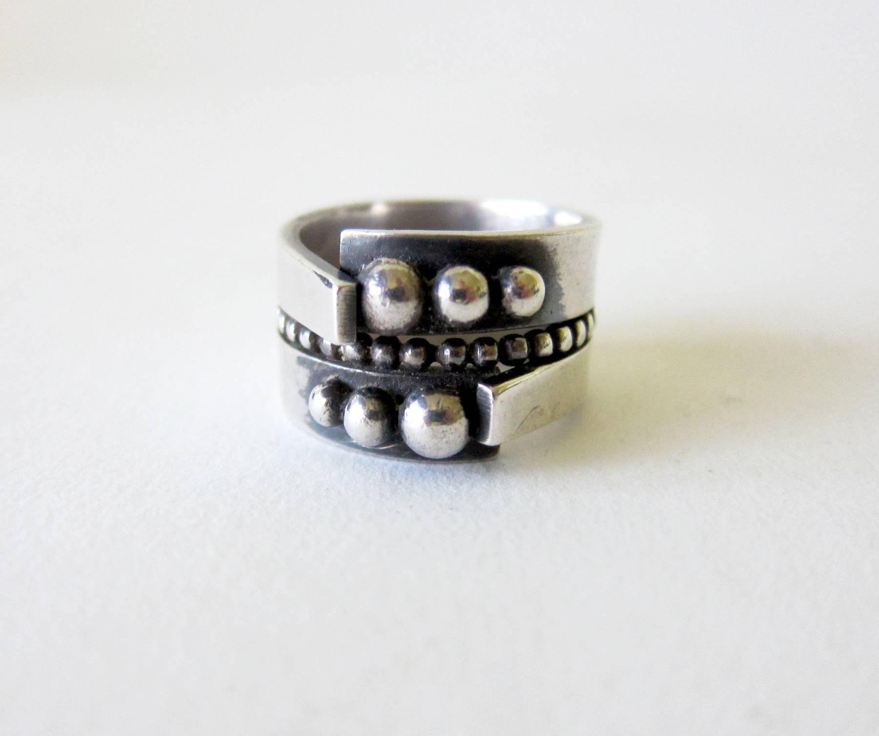 A very involved sterling silver ring with ball decoration on face and around the shank creat by James Parker of San Diego, California.  Ring is a finger size 8, shank measures 1/2