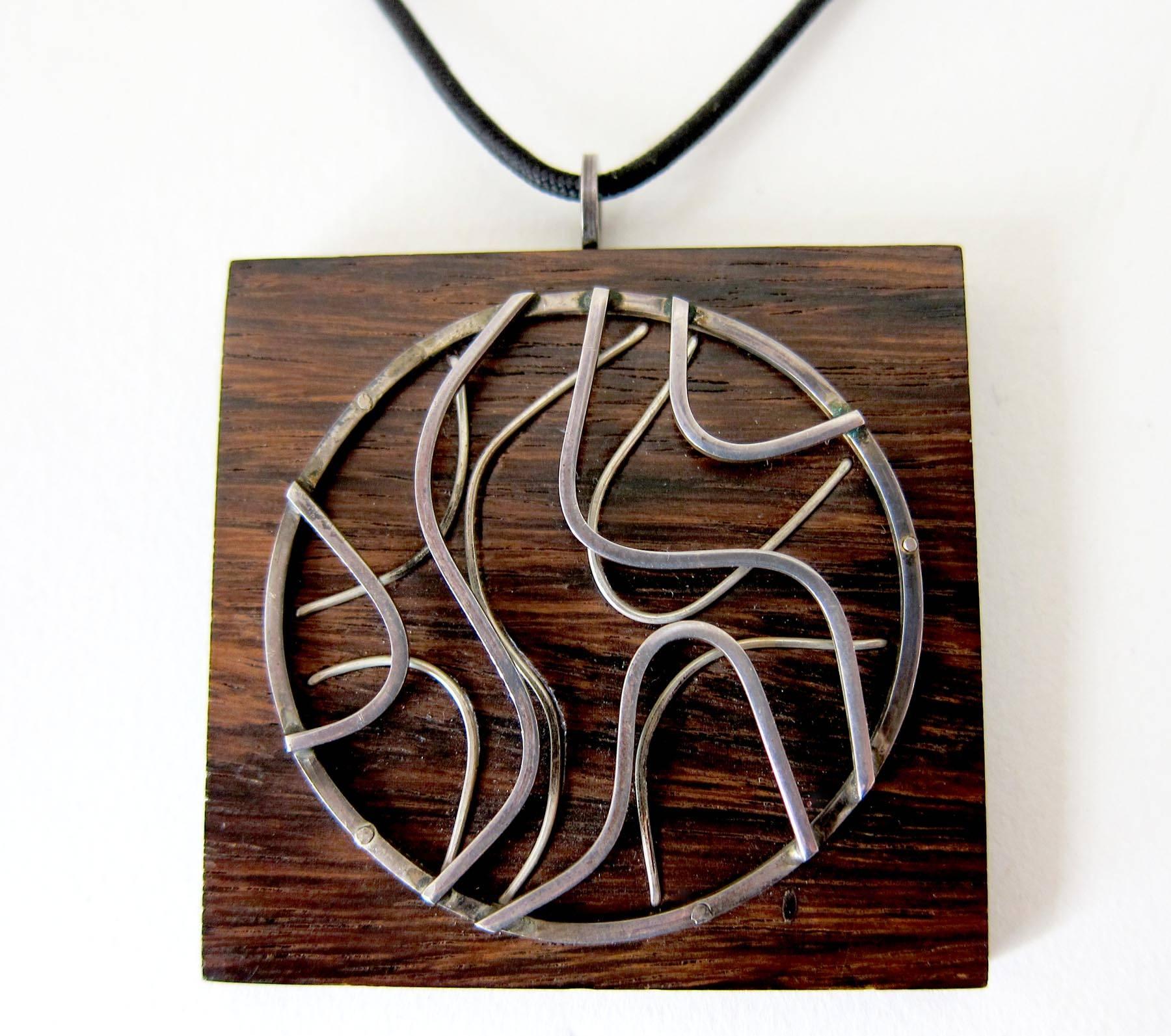 California studio exotic wood pendant necklace with applied hand forged sterling design created by Milton Cavagnaro of Mill Valley, California.  Pendant measures 2