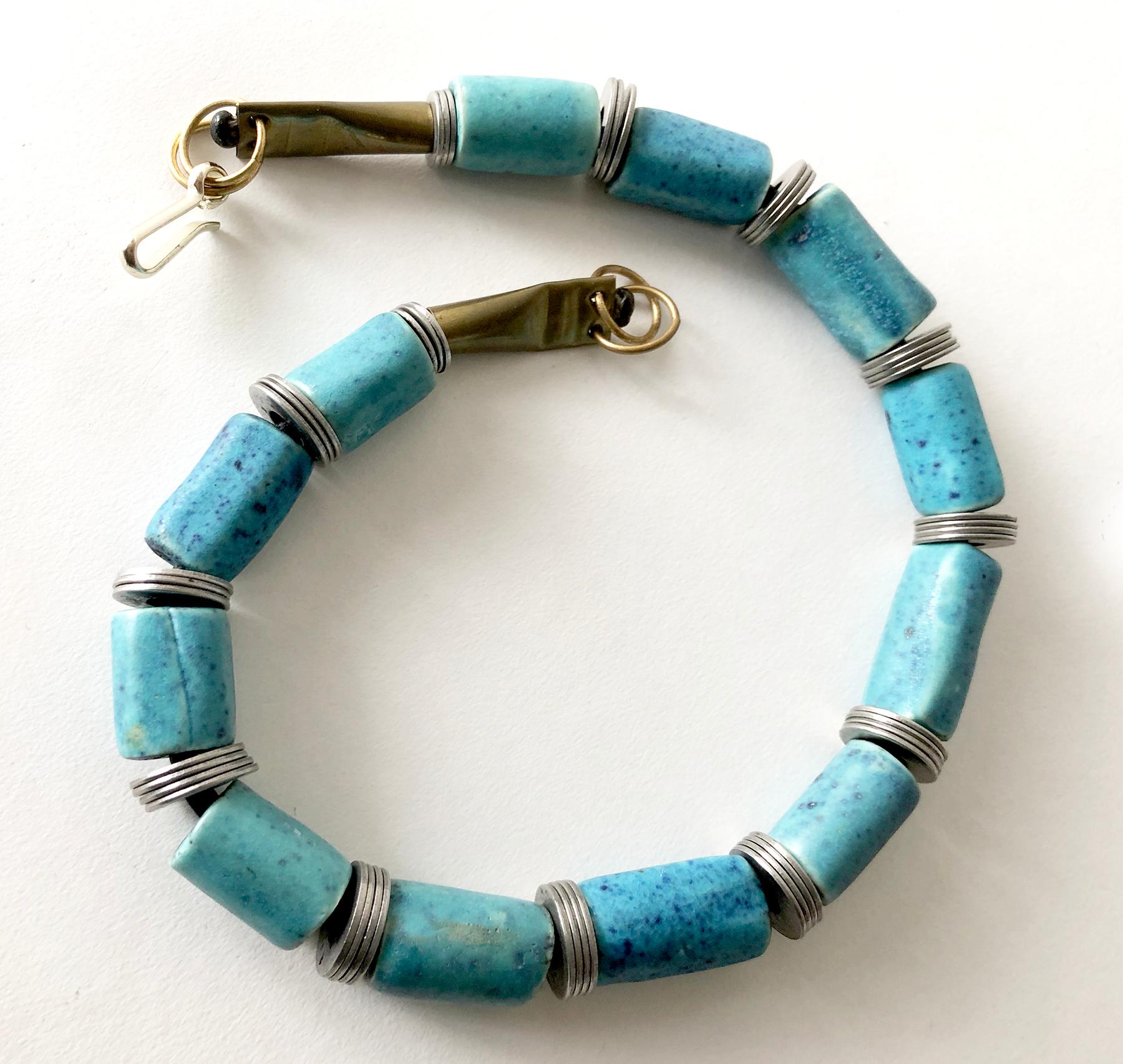 Handmade necklace of twelve cylindrical mottled turquoise beads separated by steel washers, created by Doyle Lane of Los Angeles, California.  Necklace measures 20