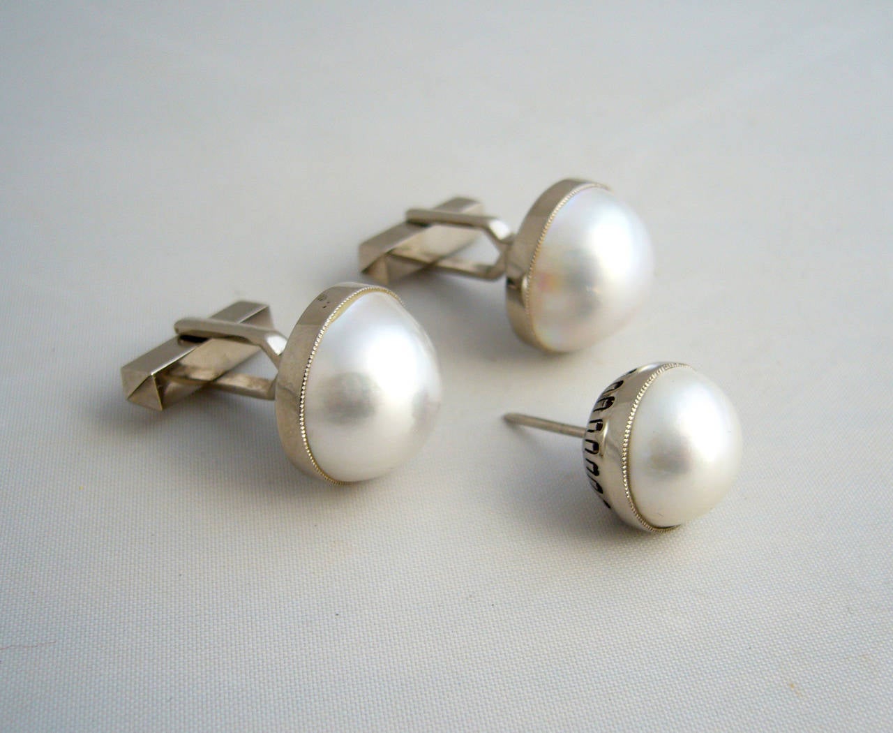A 14k white gold and mabé pearl cufflink and tie tack set, circa 1950's.  Cufflinks measure 5/8
