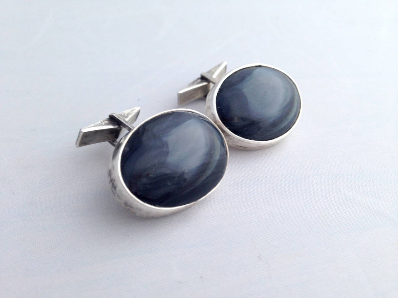 A pair of dark blueish black agate and sterling silver modernist cufflinks created by C. Bishop, circa 1950's.  Cufflinks measure 1