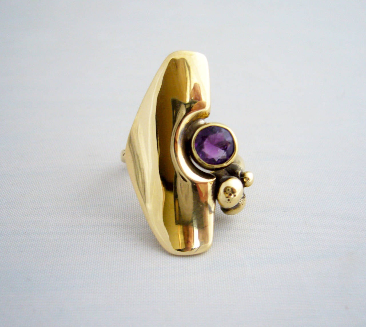 A bronze ring with faceted amethyst stone created by Jack Boyd of San Diego, circa 1970's.  Ring is a finger size 5.5 and is in excellent condition.  Signed with the artists conjoined JB cypher.