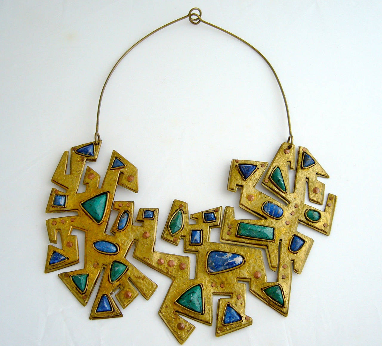 A handmade necklace, of abstract puzzle-cut design made from brass, copper and natural gemstones.  Piece was created by Juan Reyes of Chile. Necklace has a wearable neck length of about 17