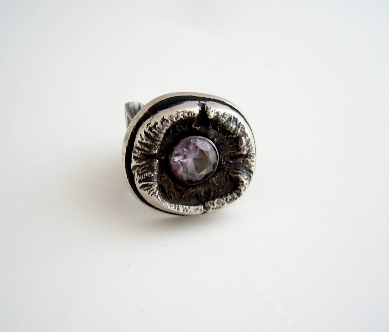 A sterling silver and a  amethyst ring created by James Parker of San Diego, California circa 1960's.  Faceted amethyst is nestled within a brutalist cave-like setting.  Ring is a finger size 9 to 9.5.   A great, unconventional alternate to a modern