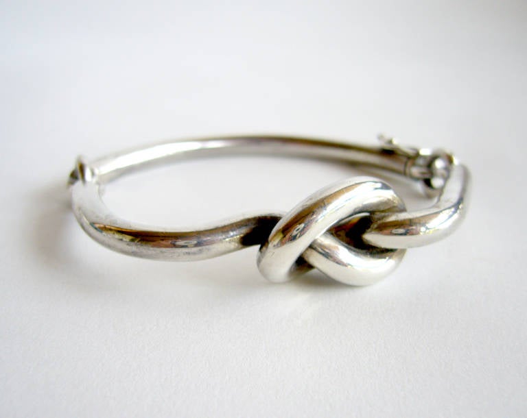 Ein röhrenförmiges Armband aus Sterlingsilber mit Scharnier und Liebesknoten:: entworfen und hergestellt von Jose Maria Puig Doria aus Barcelona:: Spanien.  Armband hat eine tragbare Handgelenk Messung von etwa 7 1/2 