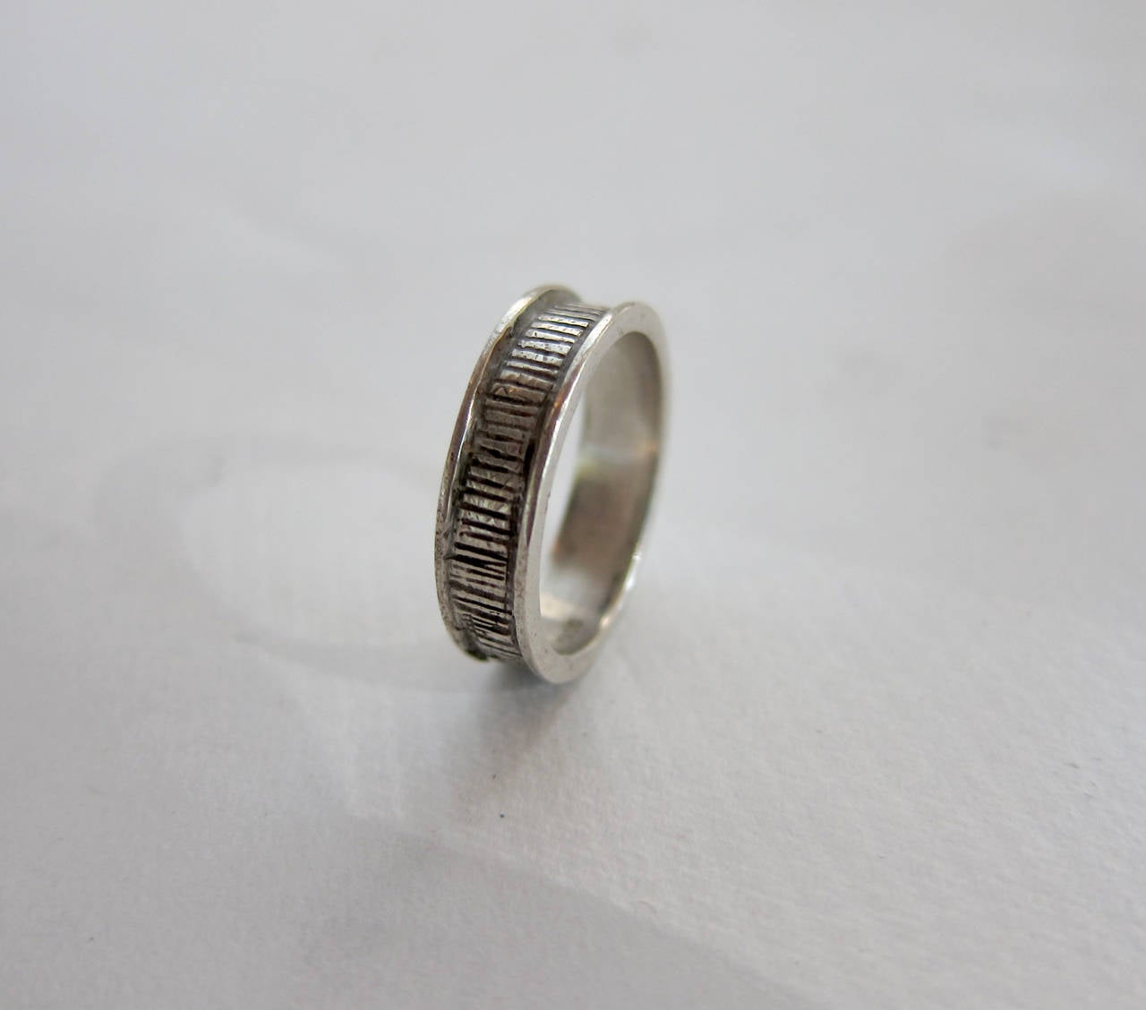 Sterling silver ring made by mid century modernist jeweler Peter Macchiarini of San Francisco, California.  Ring features a scribed design.  A finger size 6.75 and signed MACC, Sterling.  In very good vintage condition.