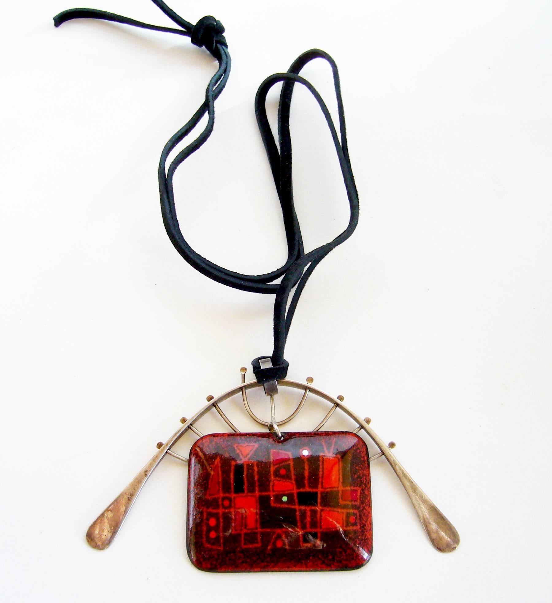 Enamel with abstract design surrounded by a sterling silver cage pendant by Barney Reid of San Diego, California.  Reid was a founding member of the Allied Craftsmen and member of the San Diego Art Guild.

Pendant measures 2.25