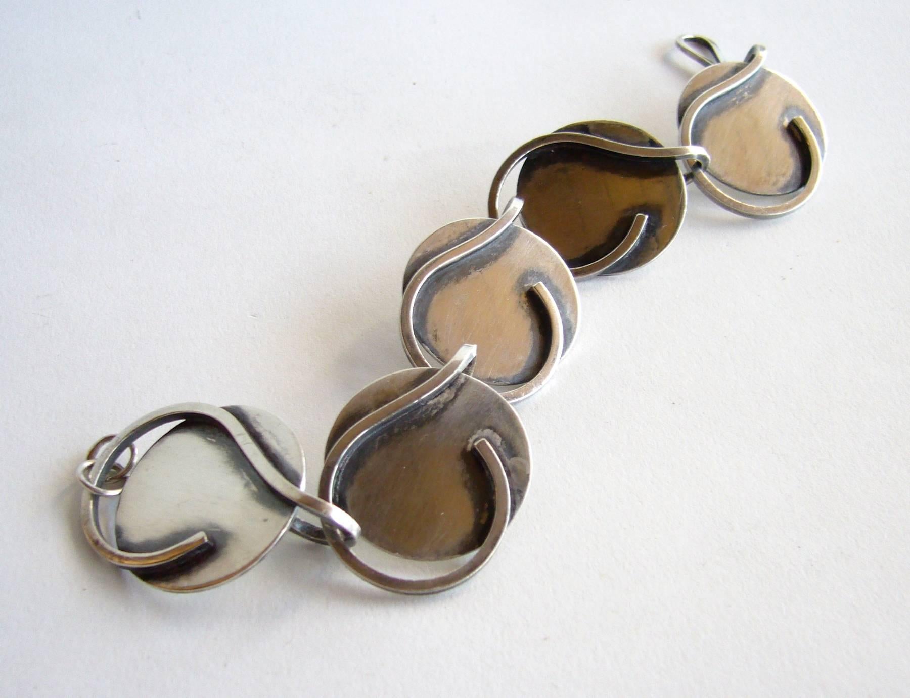 Sterling silver abstract modern linked bracelet created by Bill Tendler of New York, New York.  Bracelet is comprised of five disc with attached question mark design and measures 7 3/4