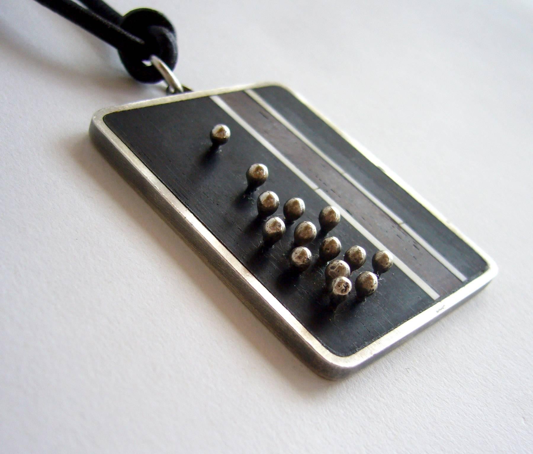 Modernist inlaid exotic wood and sterling silver pendant created by jeweler Jay Tuttle of San Jose, California.  Pendant is well made with skillful granulation of silver balls on posts as a part of the design. Pendant measures 2