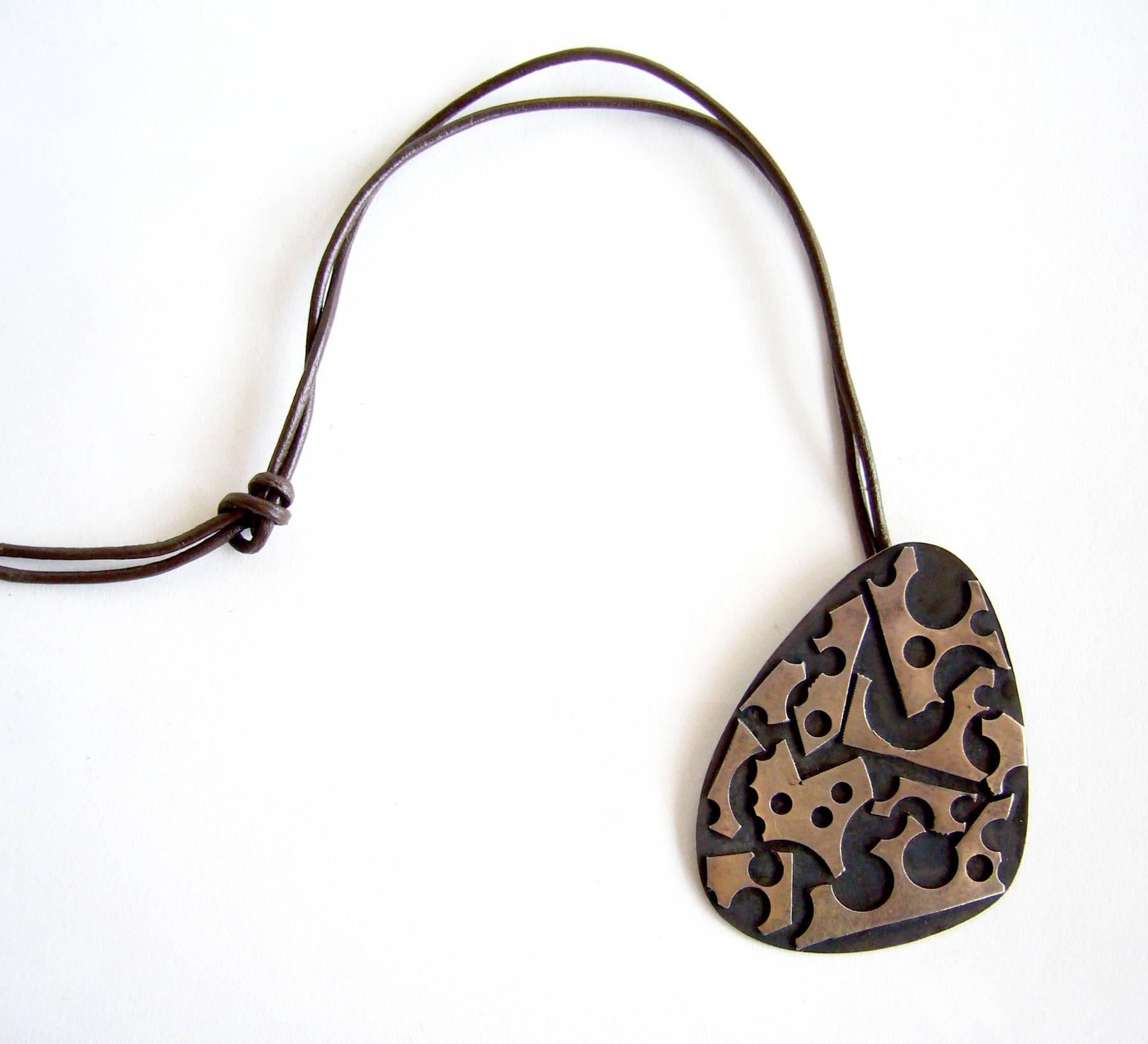Oxidized sterling silver pendant created by silversmith James Parker of San Diego, California.  Parker was an early member of the Allied Craftsmen of San Diego which started in the 1940's.  His jewelry was featured in the show 