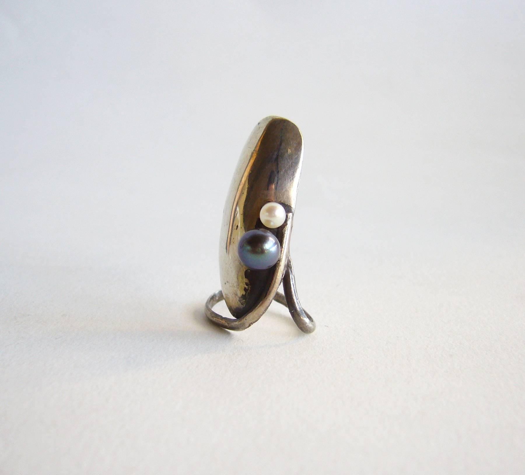 Unusual sterling silver ring made to cover your nail, circa 1980's.  Ring is embellished with two pearls as pictured.  The ring is out of round intentionally so as to fit and stay on at the finger tip, measuring about an inch or so.  Appears to be