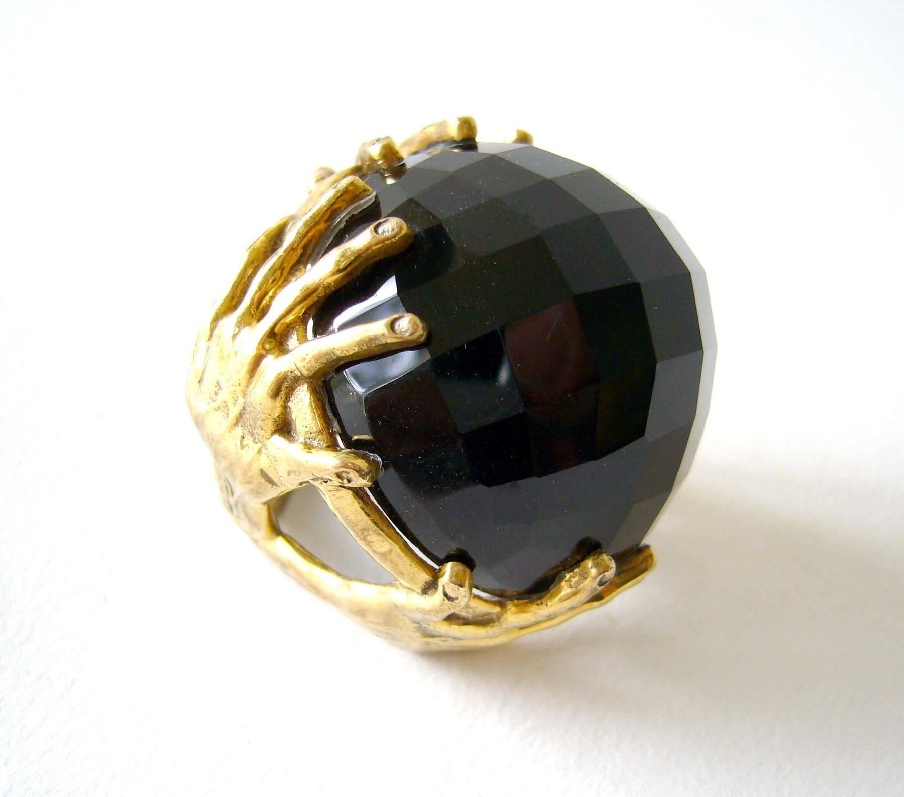 Large faceted smokey quartz sphere upheld by a surrealist bronze hands setting.  Sphere stands about .75