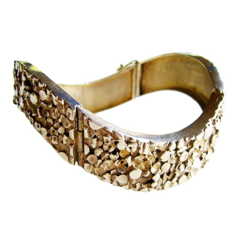 A sterling bracelet designed by the Finland Jewelry house, Kultateollisuus Ky.  Kultateollisuus Ky employed many great designers, one of which was Jorma Laine. This bracelet features a heavily textured technique.  A beautiful piece and with good