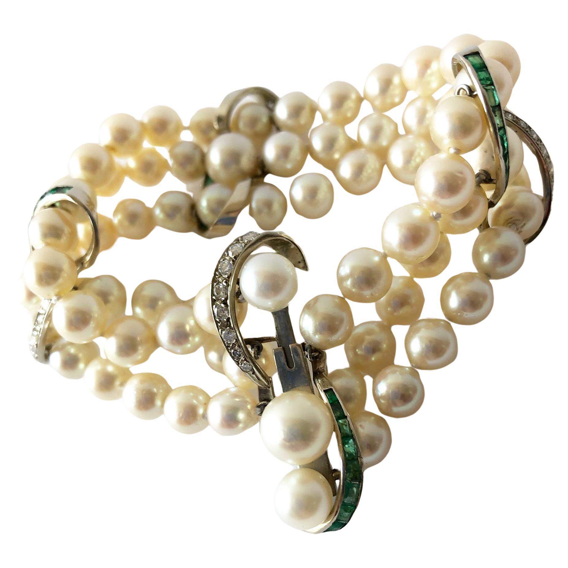 Luxurious three strand pearl bracelet with 14k white gold accents containing channel set emeralds and diamonds.  Emeralds do have natural inclusions and perhaps a small chip or two. These are very hard to see with the naked eye and mostly only under