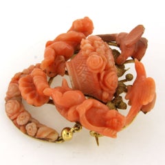 VICTORIAN brooch with coral form of cherubs, birds, and floral garlands 18k gold