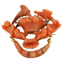 VICTORIAN brooch with coral form of cherubs, birds, and floral garlands 18k gold