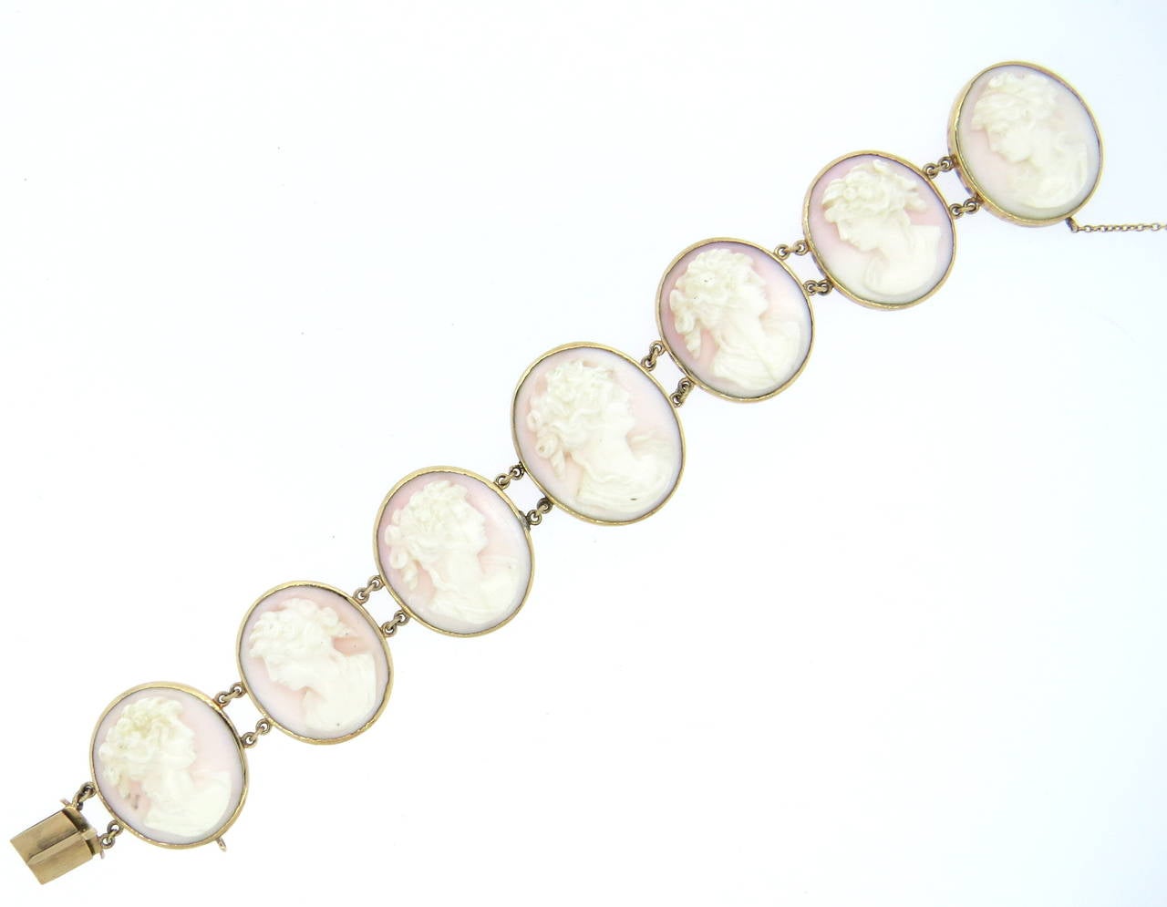 14k gold bracelet with 7 oval coral cameos, gradually measuring 24mm x 21mm to 28mm x 24mm . Bracelet is 7 1/8