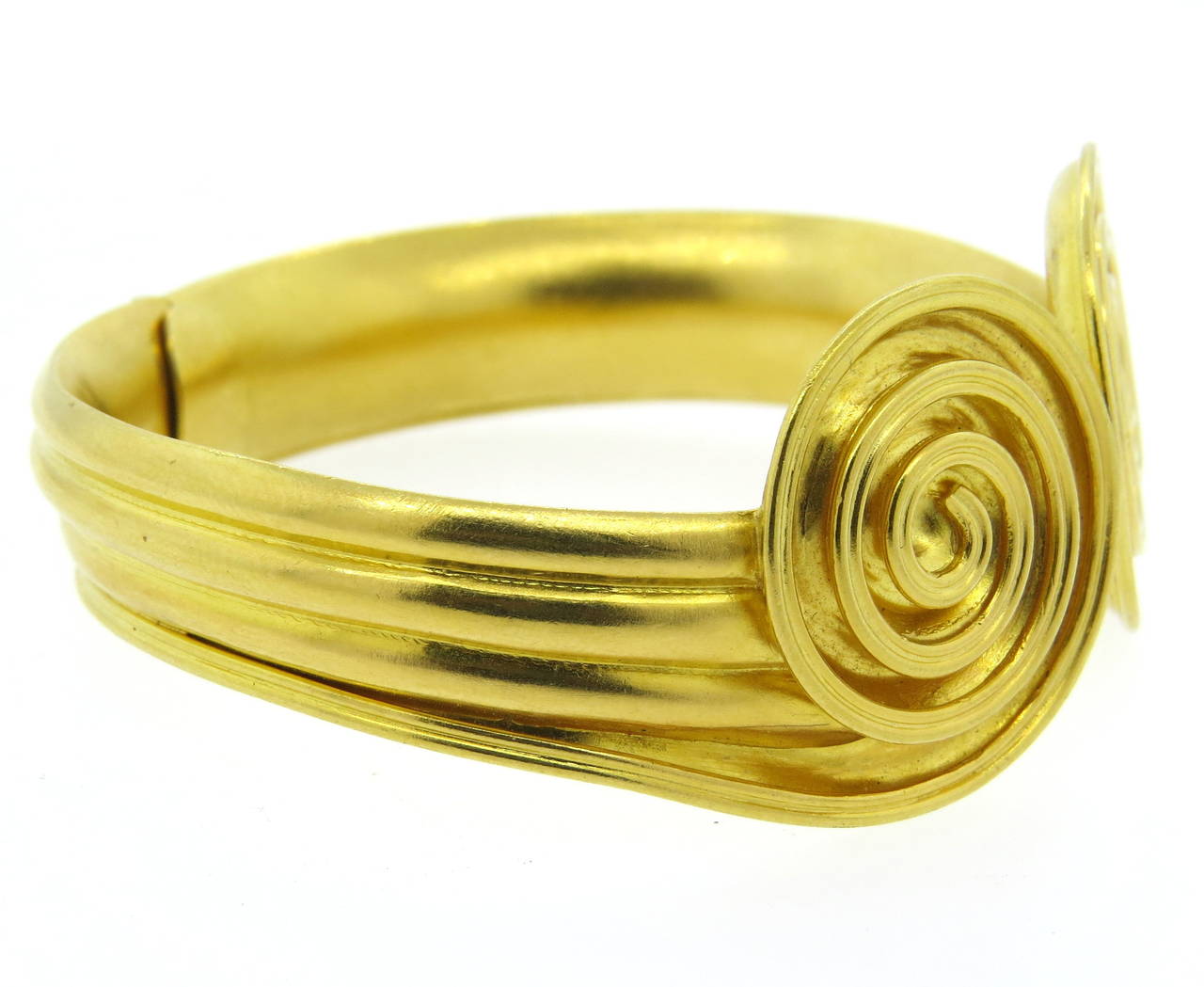 An 18k yellow gold bracelet in a swirl motif.  Crafted by Ilias Lalaounis, the bracelet comfortably fits up to a 6.5