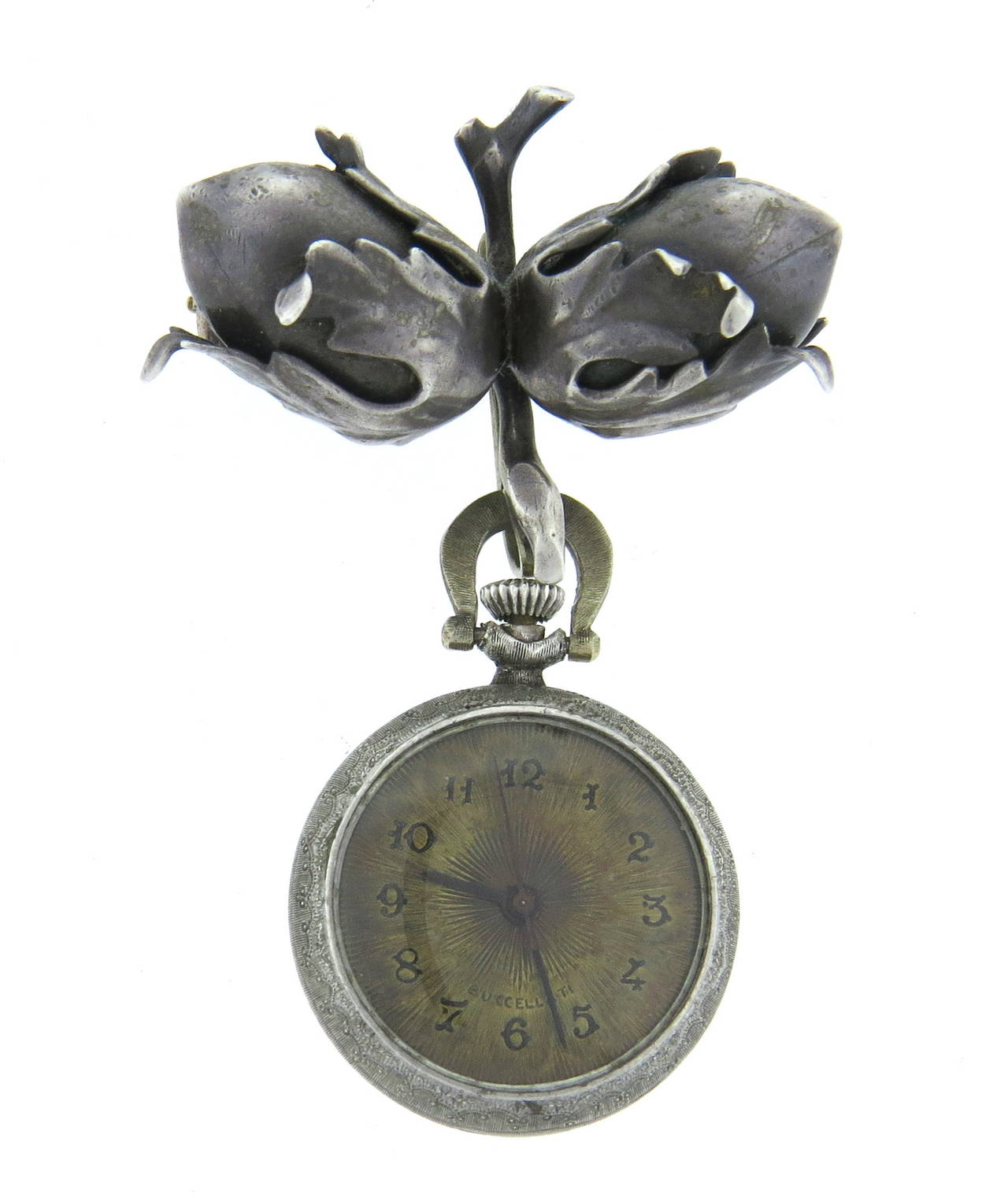 Buccellati silver acorn brooch with suspended lapel manual wind watch. Brooch measures 37mm x 26mm (excluding the watch),  watch case measures 24mm in diameter and 33mm long with bale. Manual wind movement in running order. Dial and pin closure are