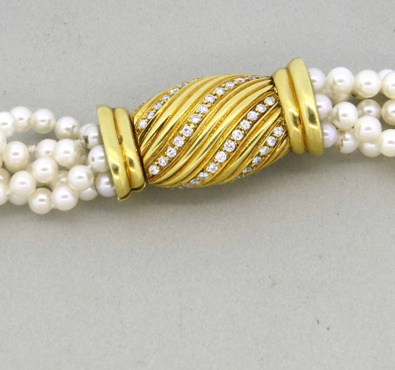 Long necklace, featuring multi strands of 4mm - 4.5mm cultured pearls, decorated with 18k gold and 1.30ctw G/VS diamond clasp. Necklace is 36