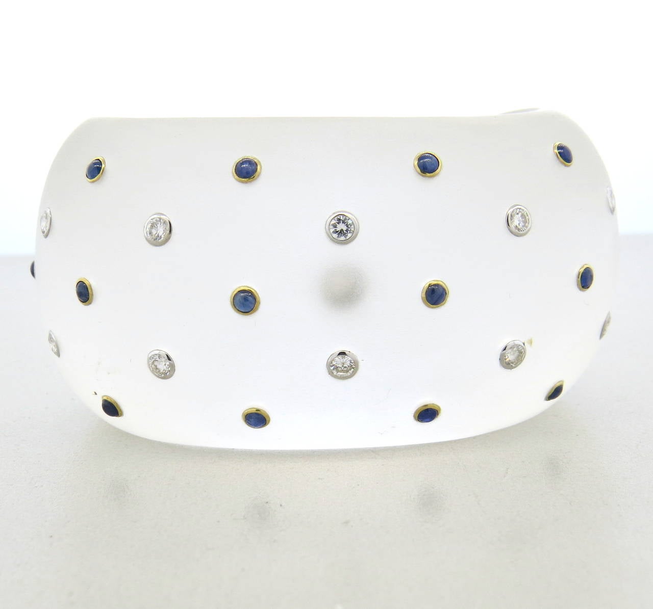 Trianon wide cuff bracelet in frosted crystal, decorated with diamonds and sapphires with 18k gold. Will fit up to 6