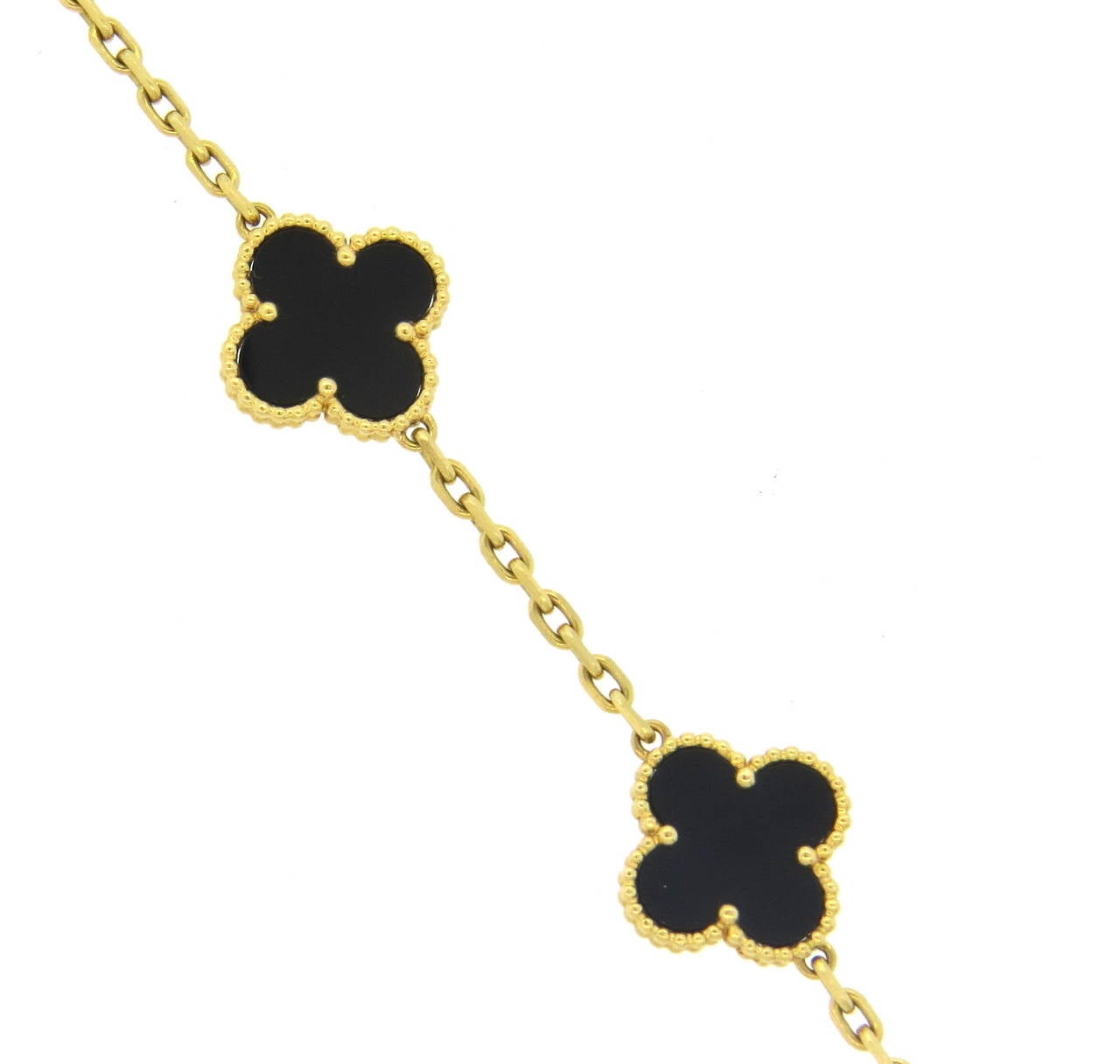 An 18k yellow gold bracelet set with onyx clover motifs. Crafted by Van Cleef & Arpels for the Vintage Alhambra collection, the bracelet measures 7.5
