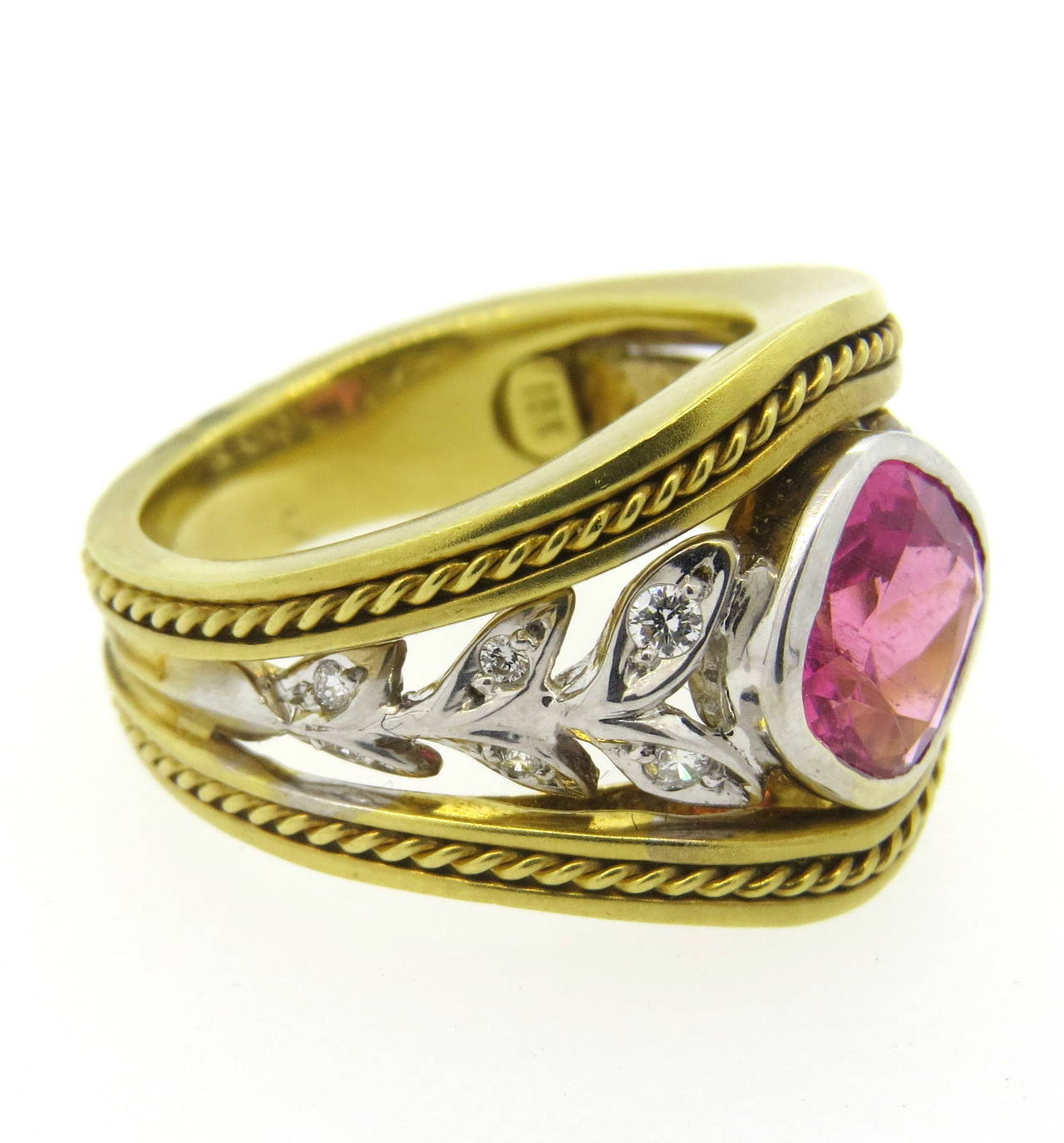 18k gold ring by Seidengang, featuring pink tourmaline in the center, surrounded with approx. 0.12ctw in diamonds. Ring is a size 6 3/4, ring is 16.5mm at widest point. Marked SG and 18k. Weight - 12.6 grams
