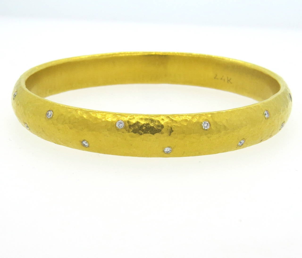 A 24k yellow gold bangle bracelet set with approximately 0.70cts in G/VS diamonds.  The bangle has a diameter of 64mm and is 10mm wide.  The weight of the bracelet is 39.5 grams.