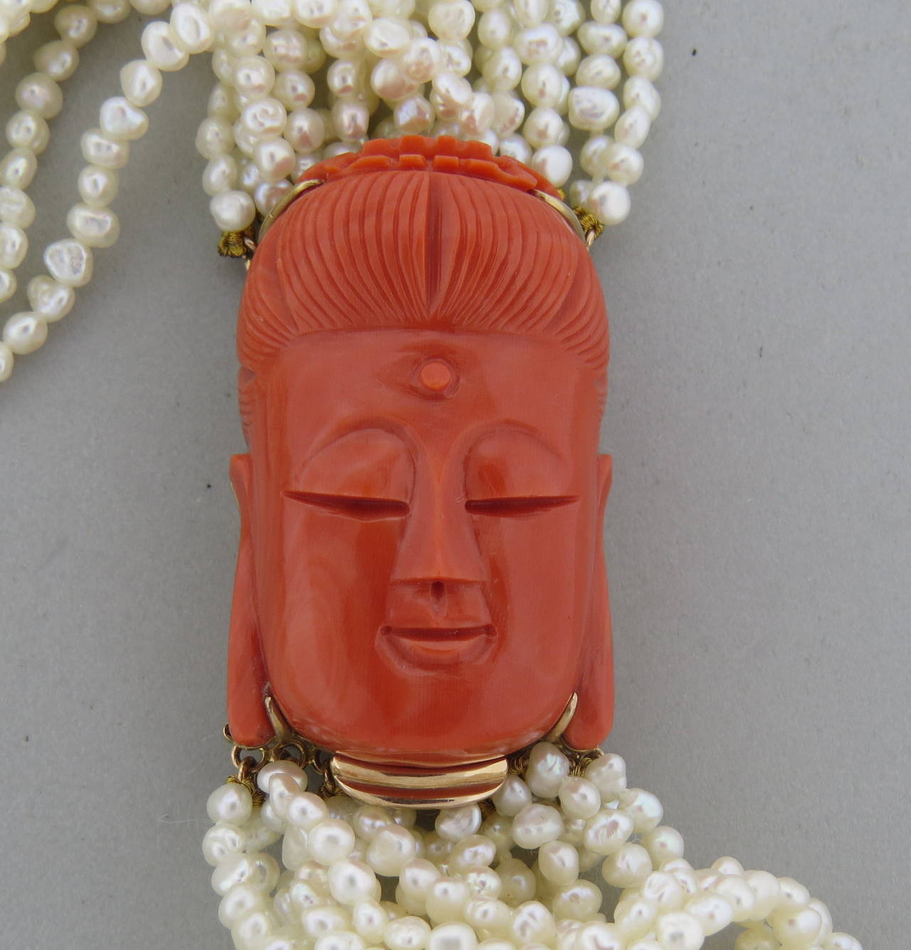 14k gold necklace, featuring carved coral 43mm x 26mm clasp, feautring happy Buddha; and multi strand 3.7-4mm pearls. Necklace is 32 1/2