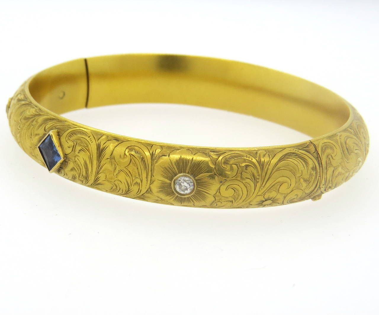 14k gold antique Victorian bangle bracelet, set with two old European cut diamonds (approx. 0.28ctw) and one sapphire. Bangle will fit up to 7