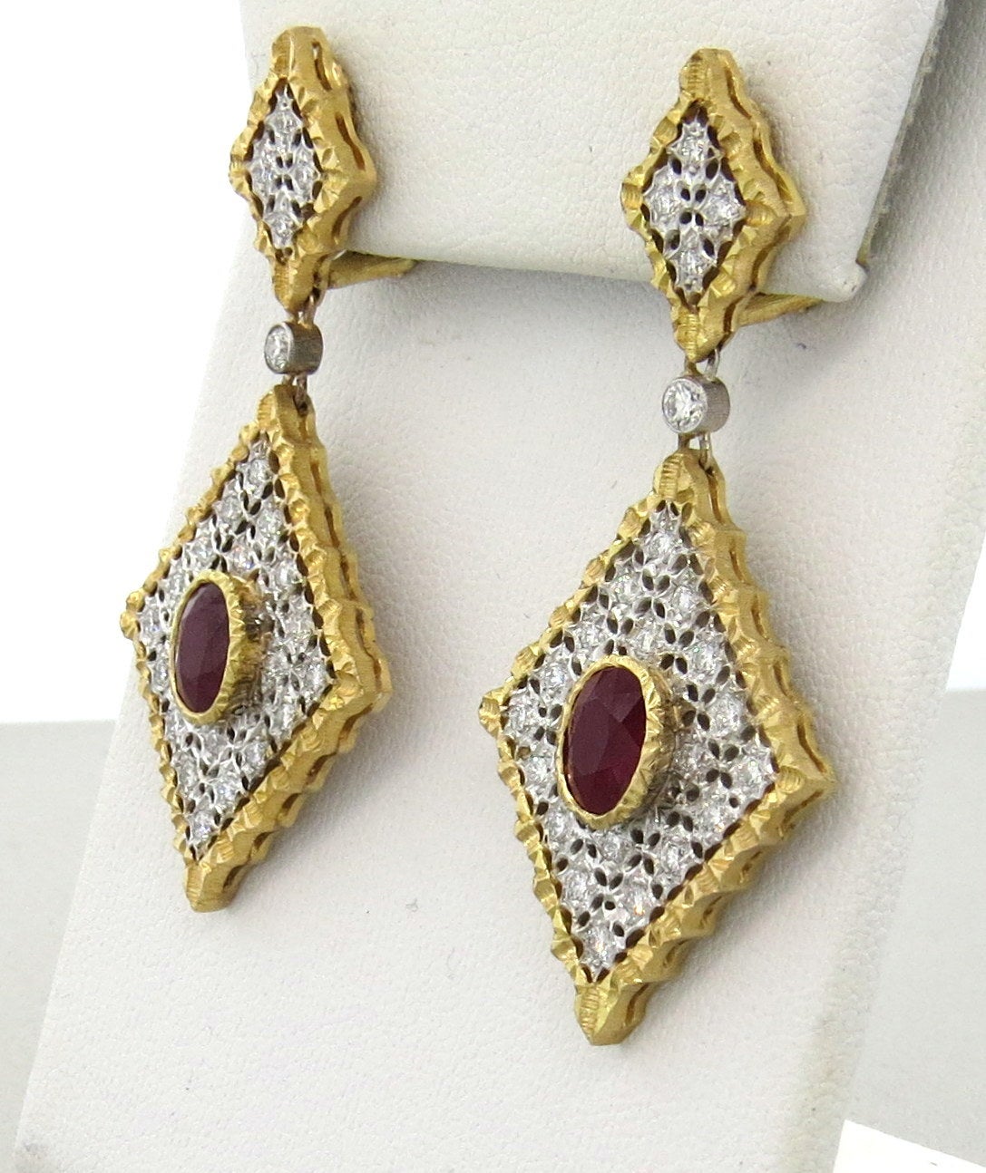 A pair of 18k yellow and white gold earring set with approximately 0.75ctw in G/VS diamonds and 2.60ctw in rubies.  Crafted by Mario Buccellati, the earrings measure 53mm x 24mm and weigh 18.9 grams.
