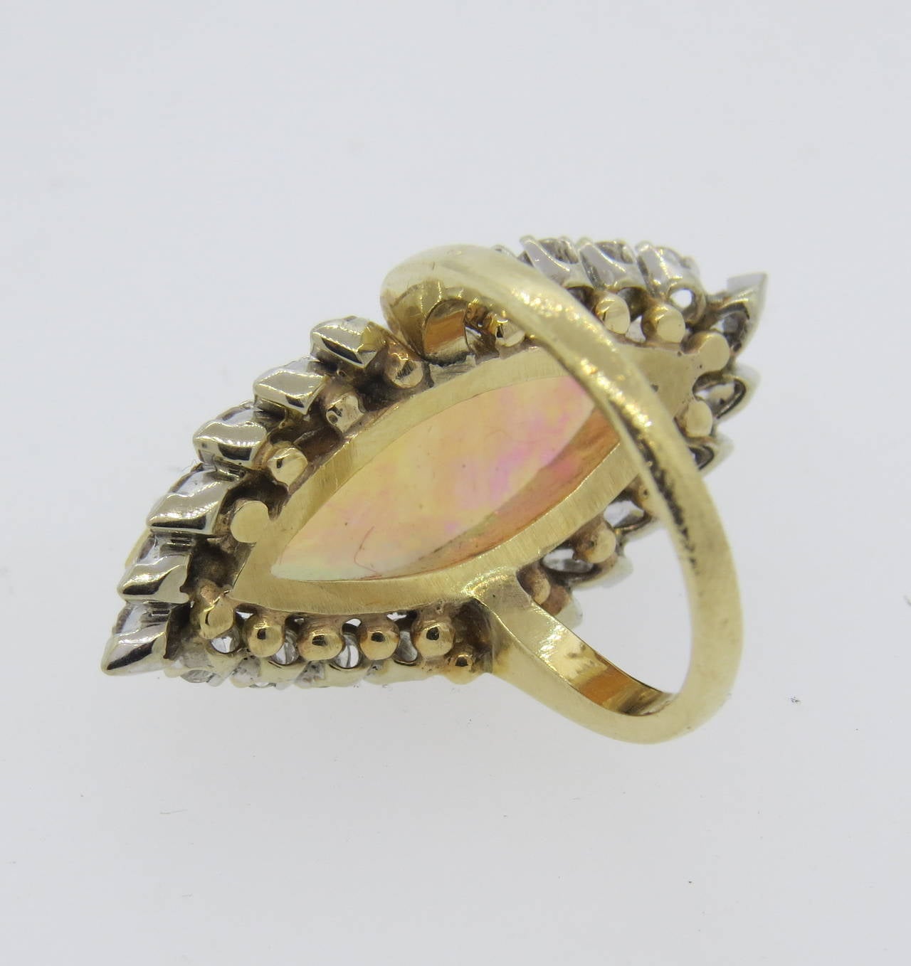 A 14k yellow gold cocktail ring set with an opal measuring 22mm x 9.5mm surrounded by approximately 1 carat of H/ VS-SI1 diamonds.  The size of the ring is 5.5 and the top of the ring measures 31mm x 15mm.  The weight of the ring is 9.6 grams. 