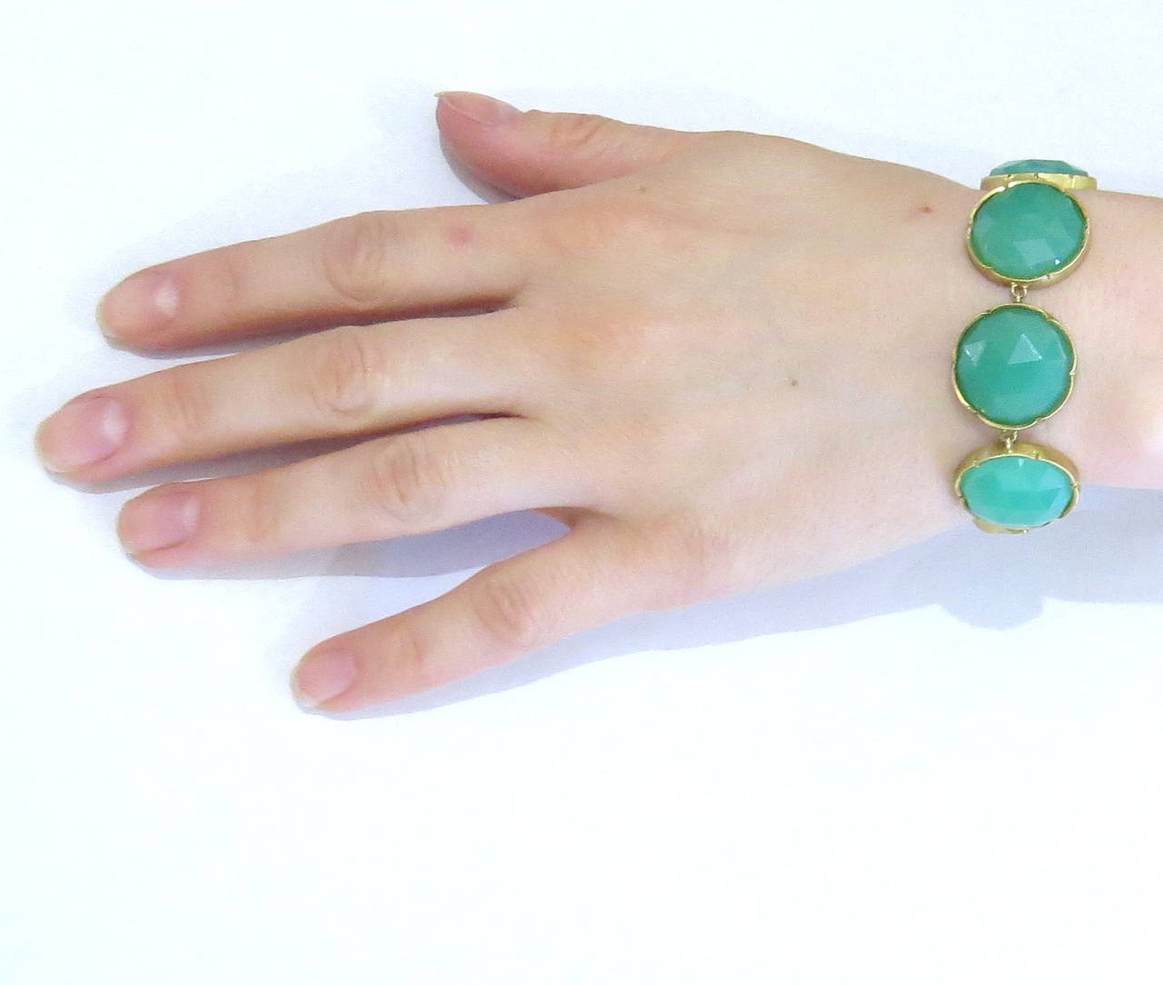 An 18k yellow gold bracelet set with faceted chrysoprase links measuring 20mm in diameter.  The bracelet is 7