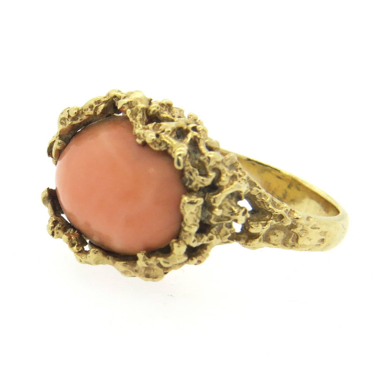 A 14k yellow gold ring set with an angel skin coral.  Crafted in the 1970s the ring is a size 7.5 and sits 11.3mm from the finger.  The top of the ring measures 22.5mm x 18.2mm.  The weight of the ring is 12.8 grams.
