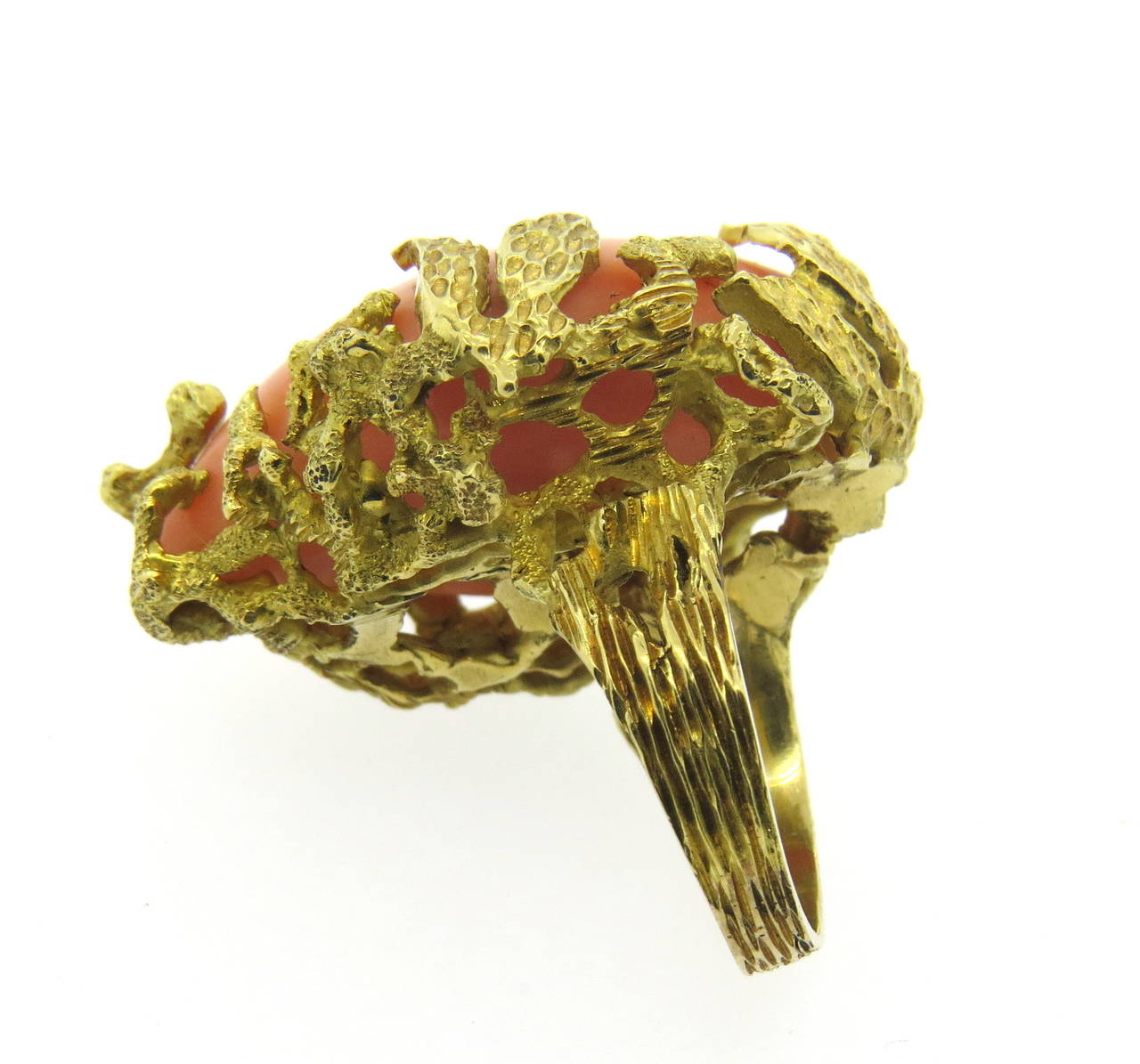 An 18k yellow gold ring set with coral, in a naturalistic theme.  The top of the ring measures 33mm x 28mm and sits 12mm from the finger.  The ring is a size 7 and weighs 24.6 grams.  Marked: 750