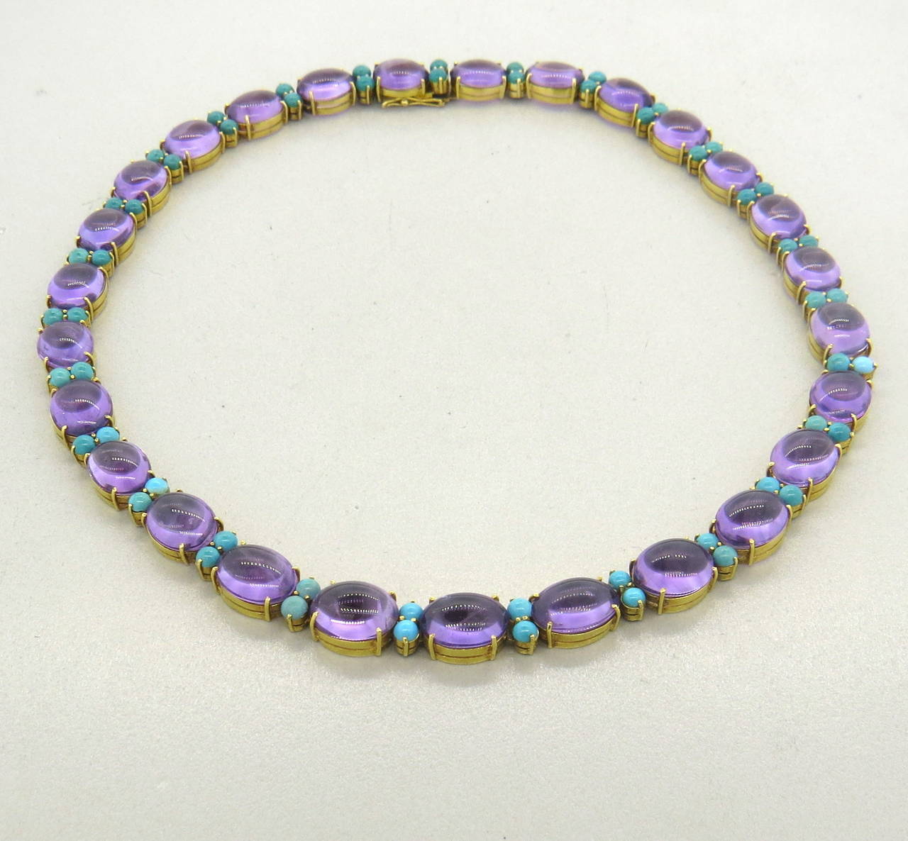 An 18k yellow gold necklace set with Amethyst (12mm x 8.5mm) and Turquoise ( 3.3mm in diameter).  The necklace measures 16